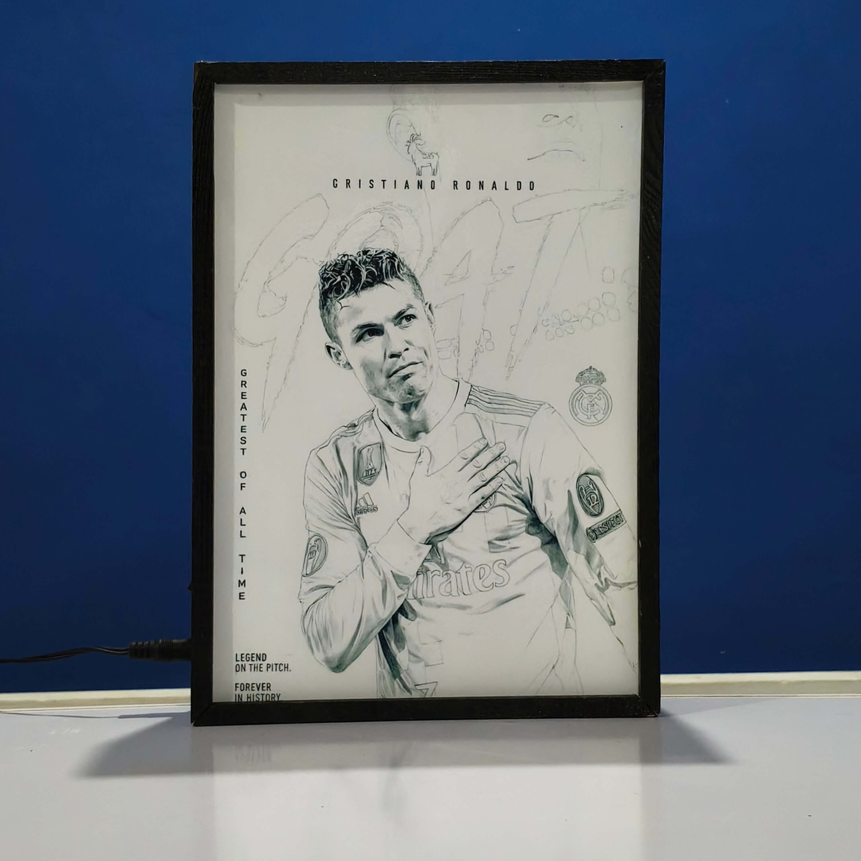 Framed artwork of a Christiano Ronaldo with text on a blue  background Backlit frame
